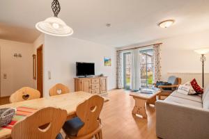a living room with a table and a couch at Fewo Brünnstein - Nr 11 Pool, Sauna in Oberaudorf