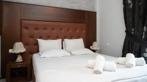 a bedroom with a large white bed with white pillows at Toti Boutique Rooms in Kalabaka