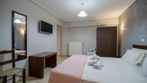 a bedroom with a bed with towels on it at Toti Boutique Rooms in Kalabaka