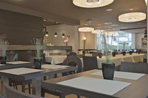 a dining room with tables and chairs and a restaurant at Zen Hotel Versilia in Marina di Pietrasanta