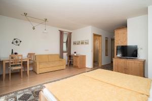 a bedroom with a bed and a living room with a television at Fürbaß Haus in St. Wolfgang