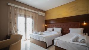 a bedroom with two beds and a window at Toti Boutique Rooms in Kalabaka