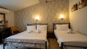 two beds in a small room with at Toti Boutique Rooms in Kalabaka