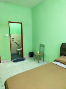a bedroom with a bed and a bathroom with a shower at Comfy Transit Tawau-Semporna in Tawau