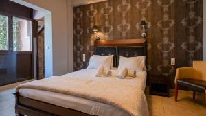 a bedroom with a bed with two stuffed animals on it at Toti Boutique Rooms in Kalabaka