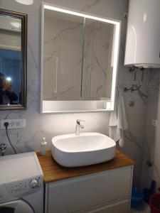 a bathroom with a white sink and a mirror at Apartman BoloB in Baška +13 photos