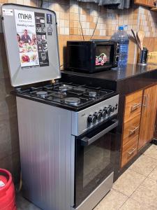 a kitchen with a stove and a microwave at Mima homes in Gatunga