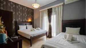 a hotel room with two beds and a window at Toti Boutique Rooms in Kalabaka