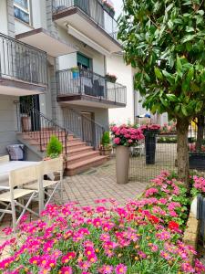 a garden with pink flowers in front of a building at Residence Valeria in Cervia