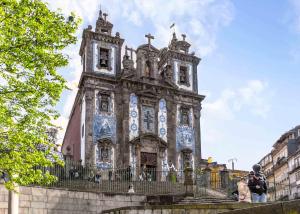 a large building with a clock tower on top at Limehome Porto Rua 31 de Janeiro in Porto