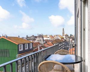 a table on a balcony with a view of a city at Limehome Porto Rua 31 de Janeiro in Porto