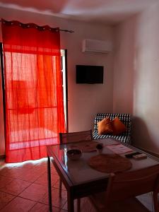 a living room with a table and a red curtain at Al Cortiletto in Palermo