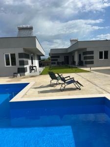 a pool in front of a building with a house at Rivi Apartments in Mrzenci