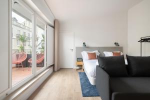 a living room with a bed and a large window at Lapa Diplomatic Suites & Flats by Feel Lisboa in Lisbon
