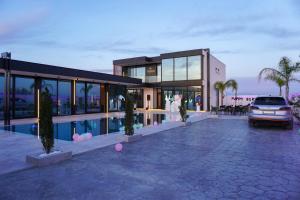a house with a car parked in front of it at Mega Luxury Villa in Rrushkull