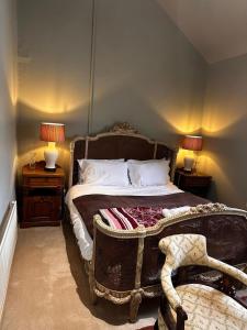 a bedroom with a bed with a chair and two lamps at Stunning 2 bed Flat Near Belvoir Castle in Croxton Kerrial +4 photos