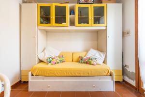 a bed with yellow sheets and pillows in a room at Casa Leo in Calasetta