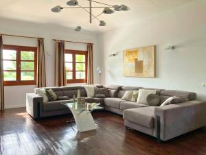 een woonkamer met een bank en een tafel bij Spacious Private Villa up to 16 - Authentic Yaiza - Volcano, Timanfaya park, Bodega & South Beaches - Heated Pool - Game Room - Charcoal grill in Yaiza +73 foto's