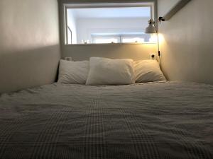 a bedroom with a bed with a window above it at Apartment in So-Fo at Södermalm 24sqm in Stockholm