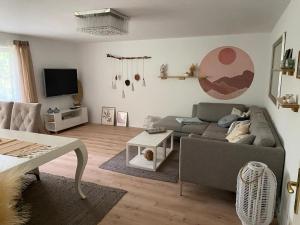 a living room with a couch and a tv at Beach & Birds in Hohenfels