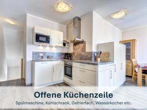 an open kitchen with white cabinets and appliances at Peenemünde, Seglerhafen_ST_Bilander 13 14 in Peenemünde +17 photos
