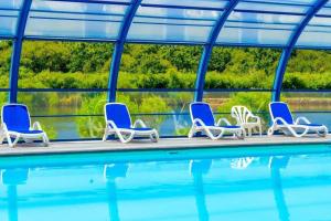 a group of chairs sitting next to a swimming pool at Camping 4 étoiles - Piscine - eeiaee in La Trinité-sur-Mer