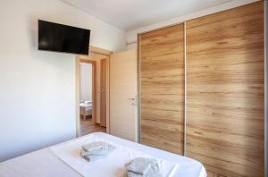 スカラ・フォルカスにあるSunkissed beachfront holiday homeのベッドルーム1室(ベッド1台、壁掛けテレビ付)