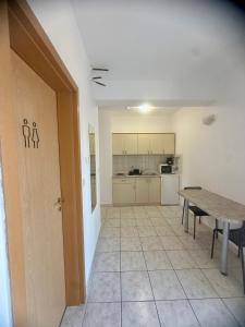 an empty room with a table and a kitchen at Apartments Ana & Ita in Novalja