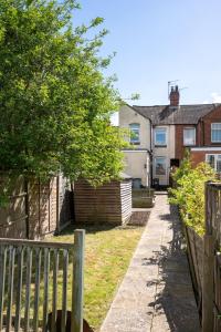 a fence next to a yard with a house at Central 2 BR Cosy House in Rugby