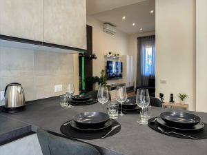 a kitchen with a table with plates and wine glasses at Rigel Apartments in Lido di Ostia