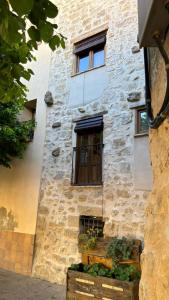 a stone building with a window and some plants at Ca la Baya in Arnés