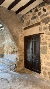 a door in the side of a stone building at Ca la Baya in Arnés