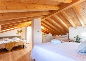 Un dormitorio con dos camas y techos de madera. en Villaggio Evanike, en Bibione 179 fotos más