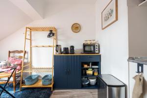 a kitchen with a blue cabinet and a microwave at Chez granny in Angers