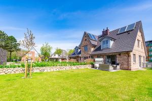 a large brick house with a yard at Haus Marit in Westerland