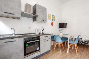 a kitchen with a sink and a table with chairs at San Siro-A 10 min a piedi da San Siro con WIFI in Milan