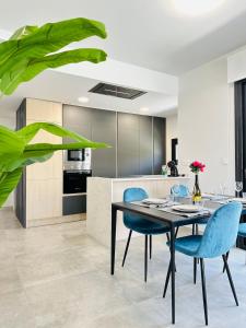 eine Küche mit einem Esstisch und blauen Stühlen in der Unterkunft Beleef Spanje new luxury apartment with sea view in Orihuela