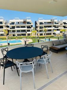 eine Terrasse mit Tisch und Stühlen und Gebäuden in der Unterkunft Beleef Spanje new luxury apartment with sea view in Orihuela