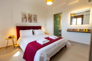 a bedroom with a large bed with a red headboard at Olivia in Pigianos Kampos +22 photos