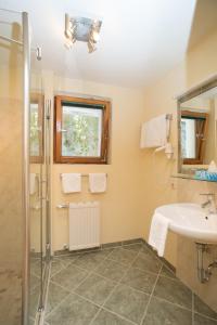 ein Bad mit einem Waschbecken und einer Dusche in der Unterkunft Fürbaß Haus in St. Wolfgang