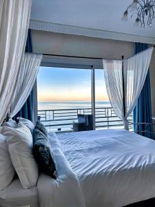 sypialnia z łóżkiem i widokiem na ocean w obiekcie Panorama Suites & Spa - Adults Only w mieście Stomio