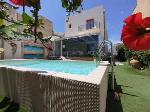 a swimming pool in front of a house at Ricordi Siciliani - Charme Rooms in San Vito lo Capo