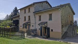 an old house with a fence in front of it at La Maison Rose in Bertignat +6 photos