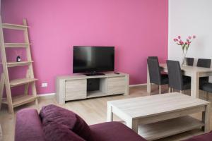 a living room with a tv and a table with chairs at Dimora Mamma Lena in Carovigno