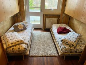 deux lits assis dans une pièce avec une fenêtre dans l'établissement carlotta&paola, à Borgata Sestriere 16 autres photos