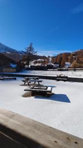un groupe de tables de pique-nique assises dans la neige dans l'établissement carlotta&paola, à Borgata Sestriere