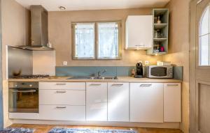 una cucina con mobili bianchi, un lavello e un microonde di Stunning Home In Meschers-Sur-Gironde a Meschers-sur-Gironde