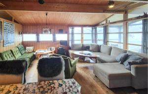 a large living room with couches and tables and windows at 2 Bedroom Nice Home In Hatlestrand in Hatlestrand