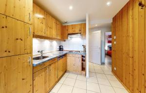 a kitchen with wooden cabinets and a sink at Gorgeous Apartment In Gérardmer With Wifi in Gérardmer