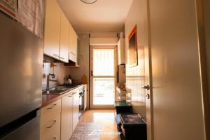 a kitchen with white cabinets and a door to a window at La Terrazza in Noicattaro